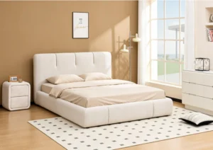 Cream boucle upholstered bed with a low platform base on a light rug, wooden nightstand beside it